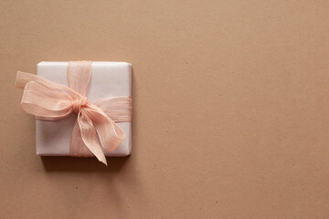 Purple gift box isolated on brown background. top view, copy space