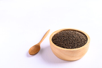 Perilla seeds in a wooden bowl and spoon on white background, Healthy herbal seed ingredients in Asian food
