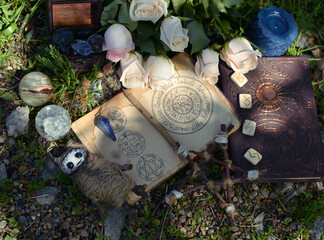 Wicca ritual with open witch diary, pentagram and voodoo doll on the grass.