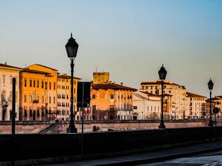 Naklejka premium 夕暮れのピサのアルノ川沿いの景色