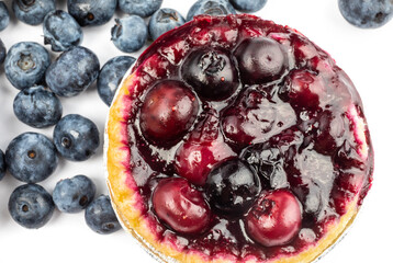 top down view of a home made blueberry tart with whole blueberries isolated on white