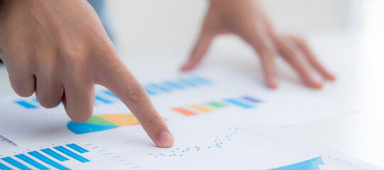 Hand of young business man pointing document data graph and chart paper, marketing and investment, report of statistics profit for financial, economic and growth of finance, management and planning.