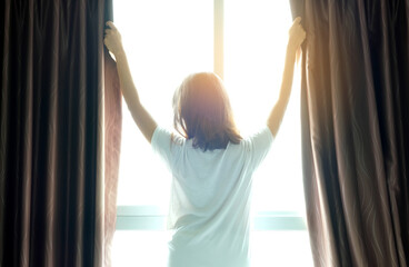 Obraz premium Morning of a new day, Women wake up from bed. In the morning, she opens the curtains in her bedroom for fresh air and natural morning sunshine.