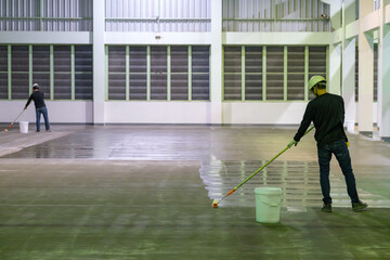 Construction worker using rollor spreading epoxy primer for Self-leveling method of epoxy floor...