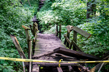 Collapsed wooden bridge in a park roped off to stop passage