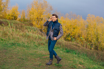 Naklejka na ściany i meble Tall handsome man outdoor in autumn forest on the hill