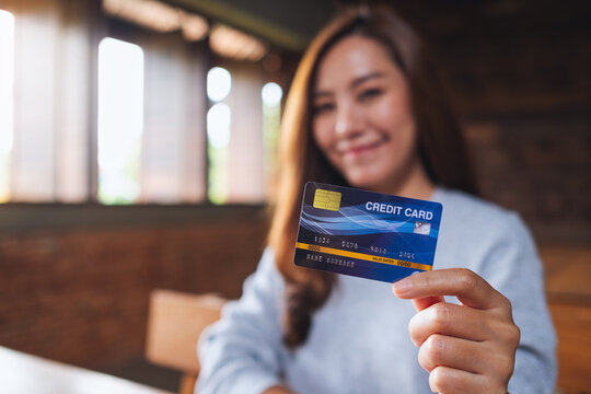 Blurred image of a beautiful asian woman holding credit card for shopping