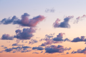 Many little clouds on orange - blue sky background. Dramatic sky during sunset. Latvia nature