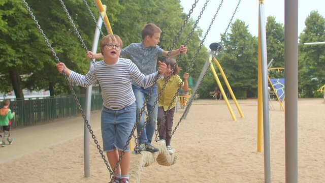 Children ride a swing. Kids recreation. Playgrounds accessible and inclusived for all. Inclusive play does mean that the combination of experiences adds to something equally great for each child. 