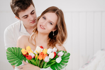 a man gave his beloved woman a bouquet of colorful tulips.