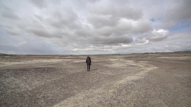 Young Woman Walking on Dry Desert Land, Bisti Badlands, De-Na-Zin Wilderness New Mexico, USA, Full Frame Slow Motion