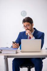 Young male employee sitting at workplace