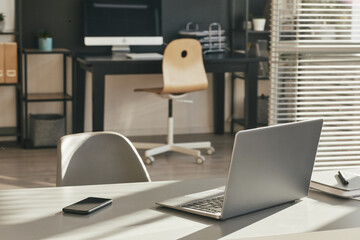 Close up background image of minimal home office desk lit by sunlight with focus on laptop, copy space