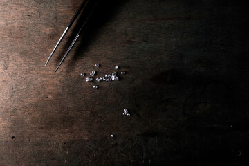 Diamond in tweezers. Craft jewelery, professional tools. Ring repairing. Macro shot. 