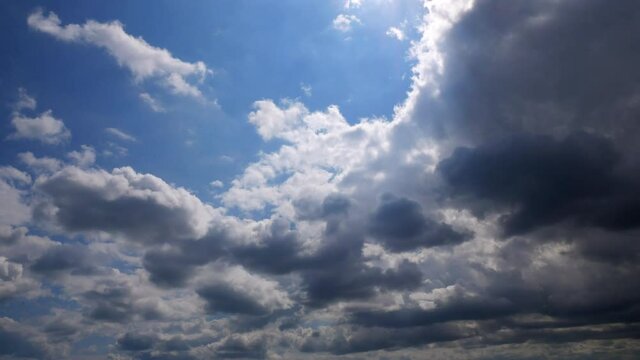 Blue sky behing rolling stormy clouds timelapse.