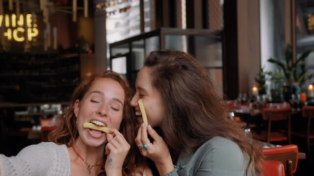Slow motion of women messing about in restaurant