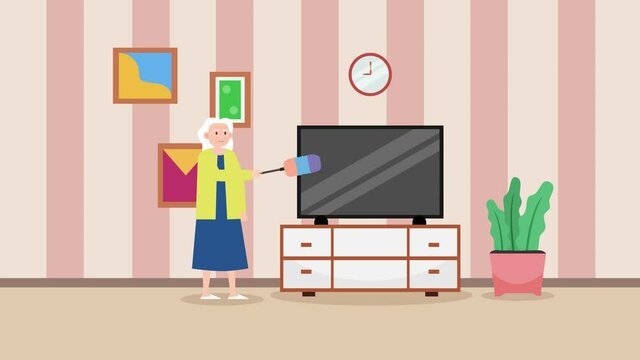Old woman cleaning the television with feather duster