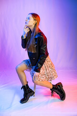 full-length portrait of a girl. A model in rough boots, a light chiffon dress and a leather jacket...