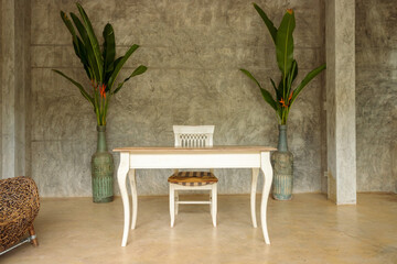 White wooden table and chairs in the living room with retro-style plaster walls..