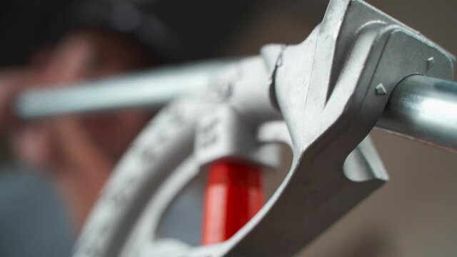 CLOSE UP, ELECTRICIAN BENDING EMT PIPE IN THE JOBSITE
