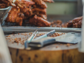 Fried chicken on chopping board and knife,tong  at street food shop so delicious food.