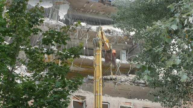 Stockholm, Sweden - 2021.08.13: Demolition of an office building in Stockholm. Heavy machinery can be seen tearing down the interior of the building.