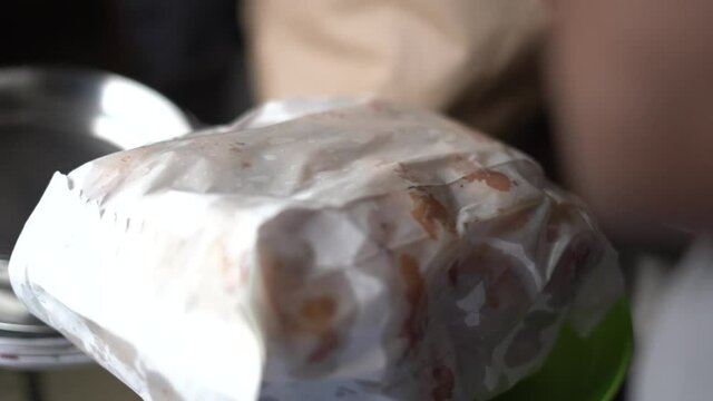 unpacking food from paper bag medu vada india.