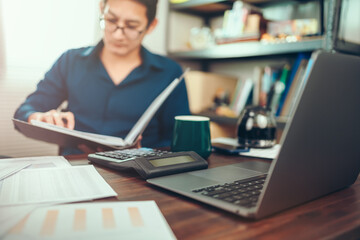 Calculator with accounting report and financial statement on desk.Accounting woking with data sheet on the office desk.