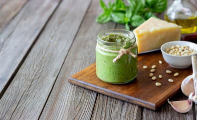 Italian pesto sauce on a wooden background. National kitchen. Healthy eating. Vegetarian food.