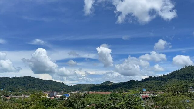 Time lapse video of sky with clouds moving across it. Beautiful white clouds at blue skies. Amasing heaven. Countryside, valley. Mountains, green hills on a horizon. Summer, greenery, town, village 4K