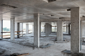 Background image of unfinished building at construction site with concrete columns, copy space