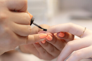 The process of manicure in a beauty salon by a specialist, with a copy of the space. Close-up