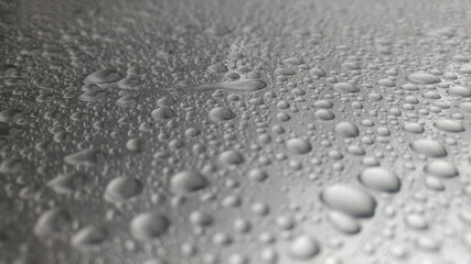 Close-up of water droplets on silver glass.