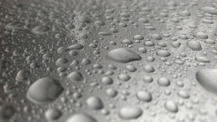Close-up of water droplets on silver glass.