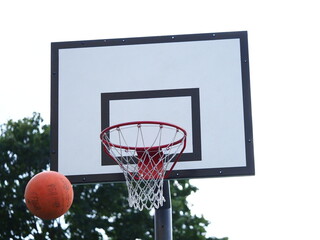 Naklejka premium ball flies into the basketball hoop on the street during the game
