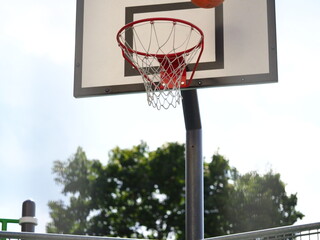 ball flies into the basketball hoop on the street during the game