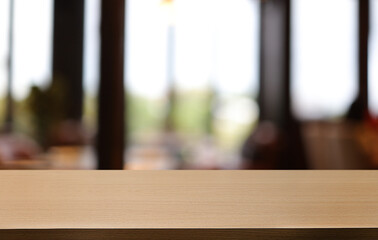 Empty wooden table in front of abstract blurred background of coffee shop . can be used for display or montage your products.Mock up for display of product