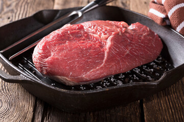 Raw meat and vegetables are prepared for grilling