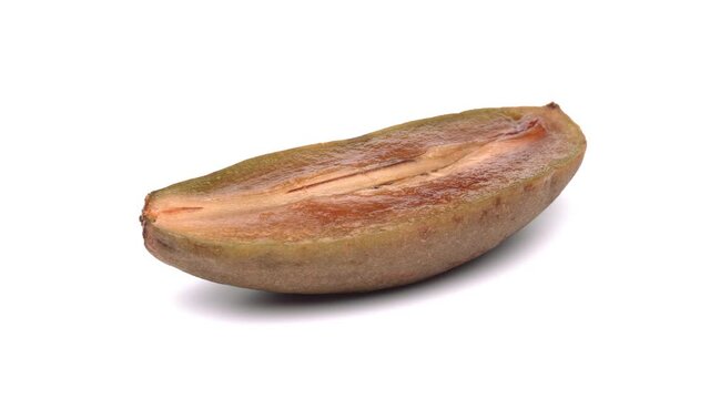 One half of sapodilla rotating on white background.