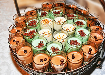 Many dessert glasses filled with coffee cream and white cream