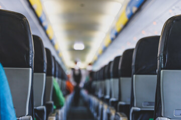 Commercial aircraft cabin with rows of seats down the aisle