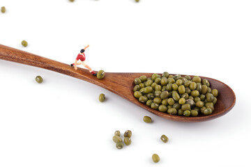 The football player on the wooden spoon kicks the mung bean into the spoon