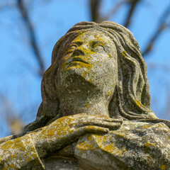 Female face made of stone on sky background