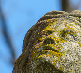 Female face made of stone on sky background