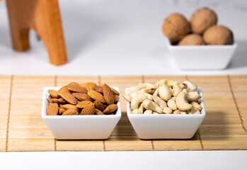 Mix of Nuts, Almond, Cashew, Wallnut in white ceramic bowls on wooden stand, Healthy snack food, Diet food