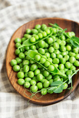 Fresh green peas pods and green peas with sprouts on textile background.