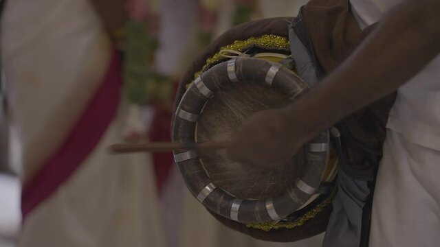 Close up gimbal shot of percussionist hands playing Thavil in wedding