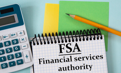 FSA - an abbreviation in a white notebook on the background of a calculator, pencil, colored pieces of paper