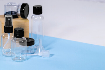 Group of Plastic clear travelling bottles for Cosmetic: soap, gel, lotion, cream, shampoo, make up and liquids on light blue Background. Modern Traveling Concept. Copy Space. Container for carryon.