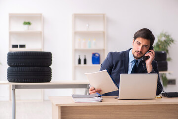 Young man selling tires in the office